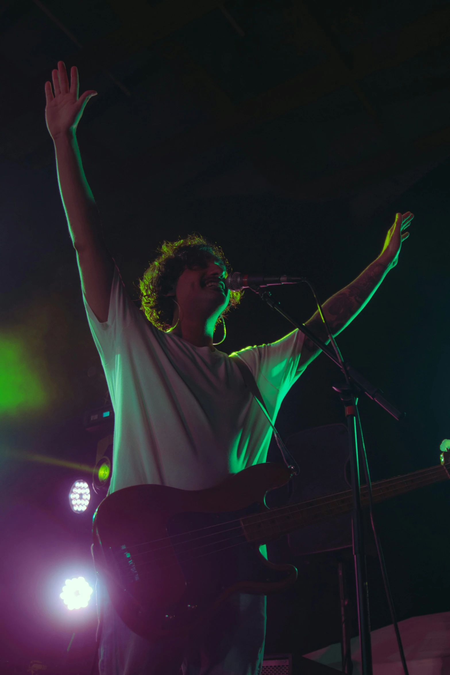 a man that is on stage singing into some microphones