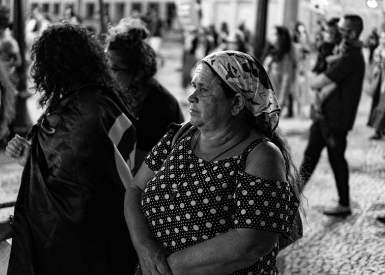 an old woman standing by a bunch of people