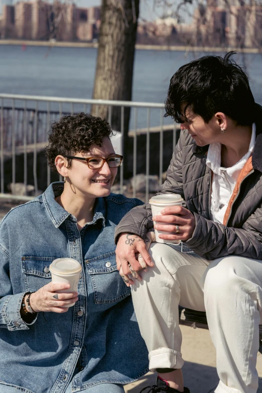 two people sit on a bench and smile at each other