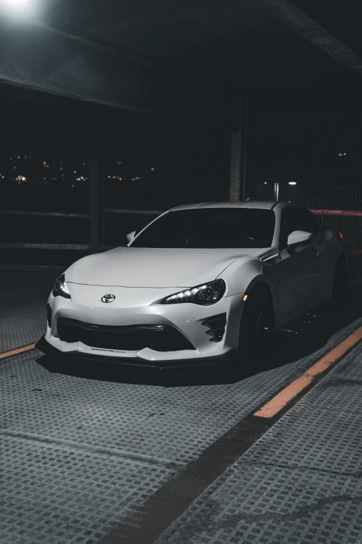 a white sports car parked in a parking garage