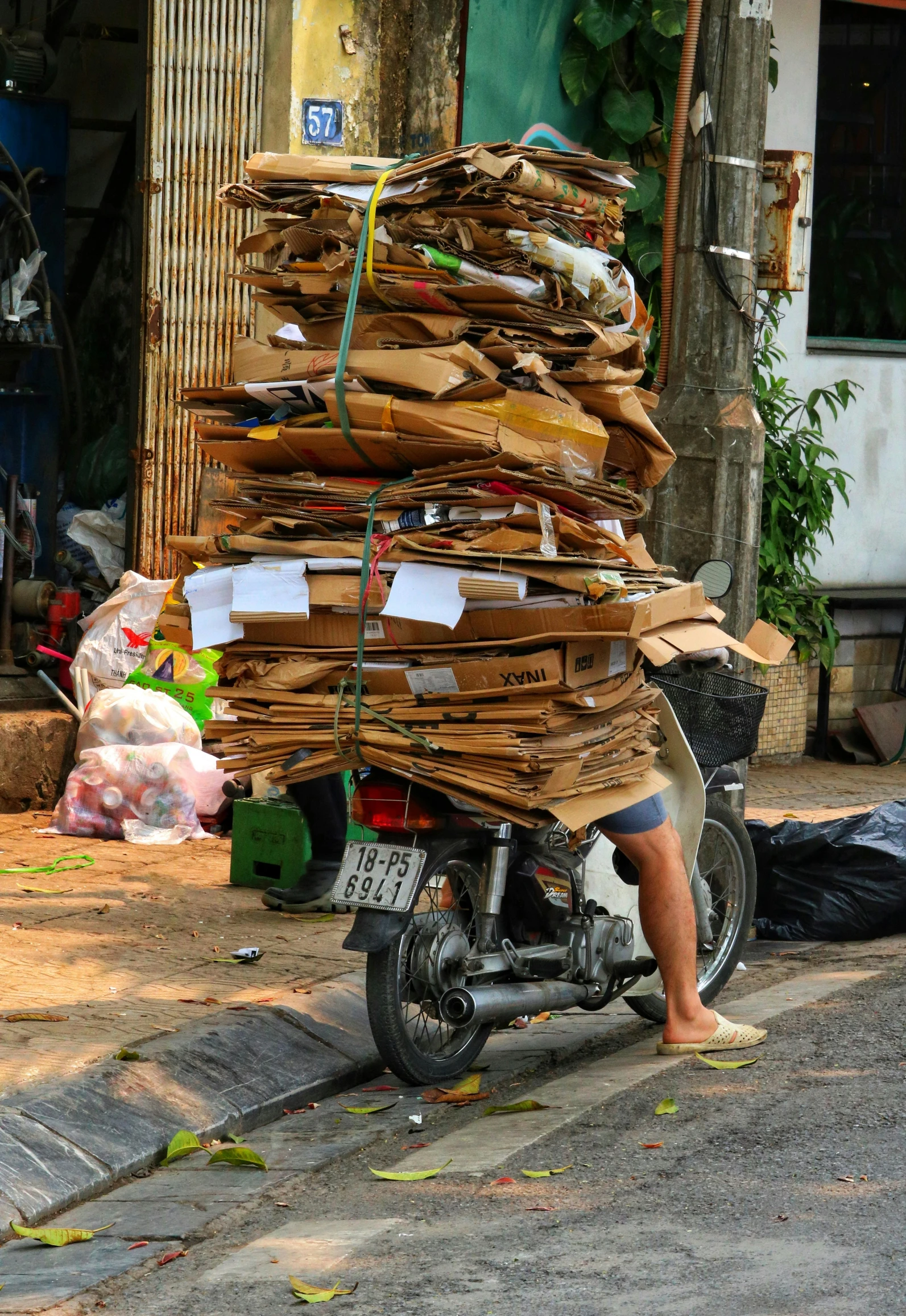 a motor scooter carrying a stack of wood with a person looking around
