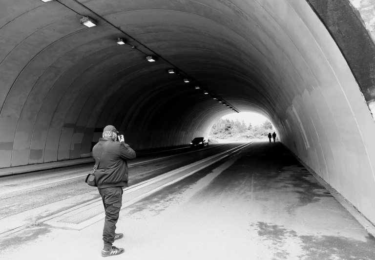 man taking po of people inside of a tunnel