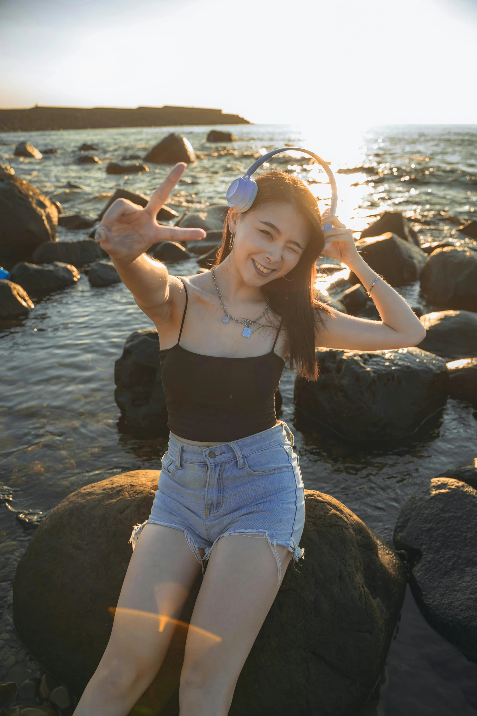 a young lady posing by rocks and smiling