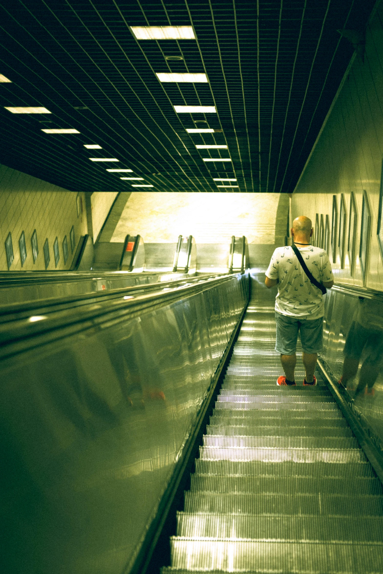 people moving down an escalator and carrying luggage