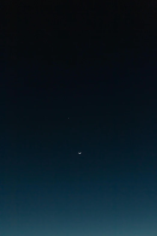 a jet flying through a dark blue sky with another plane in the background