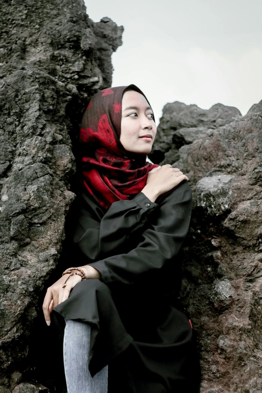 a young woman wearing a black and red hijab