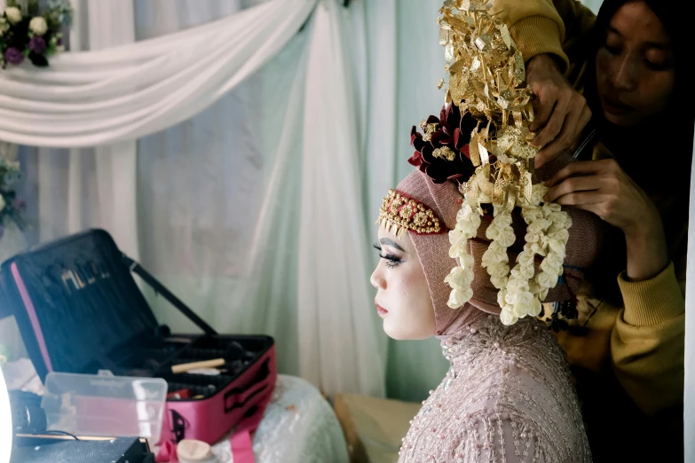 a woman wearing an elaborate head piece near her wedding luggage