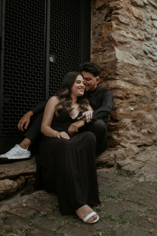 man holding a woman in his arms as they sit on steps