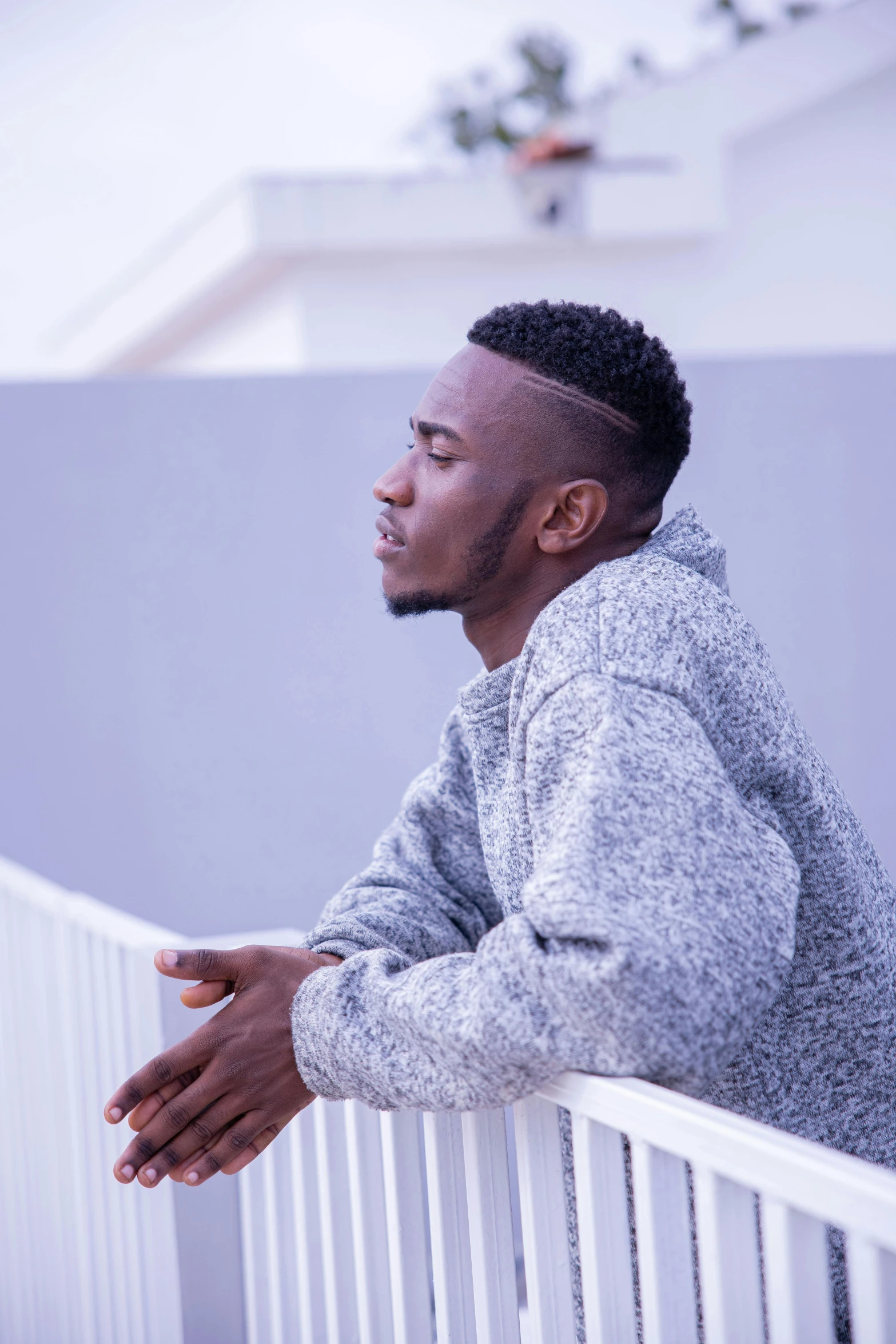 a man leaning on a railing and looking out of the window