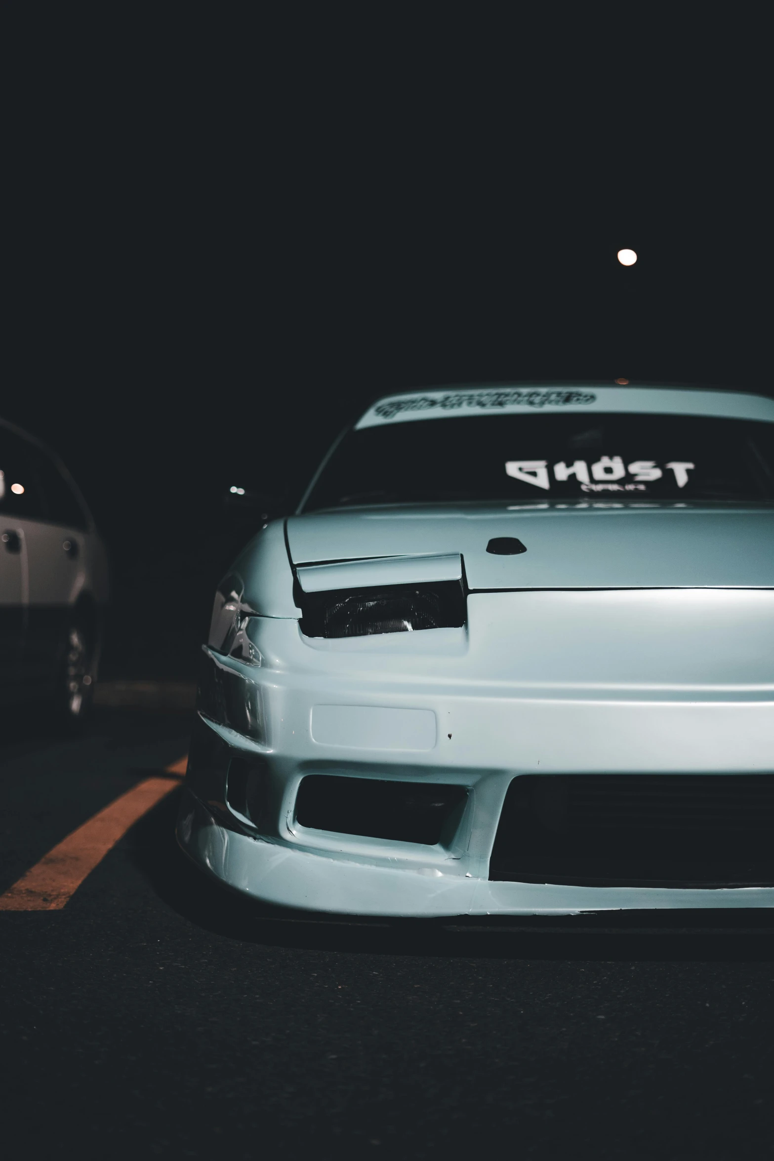 the front end of a car that is parked on the street