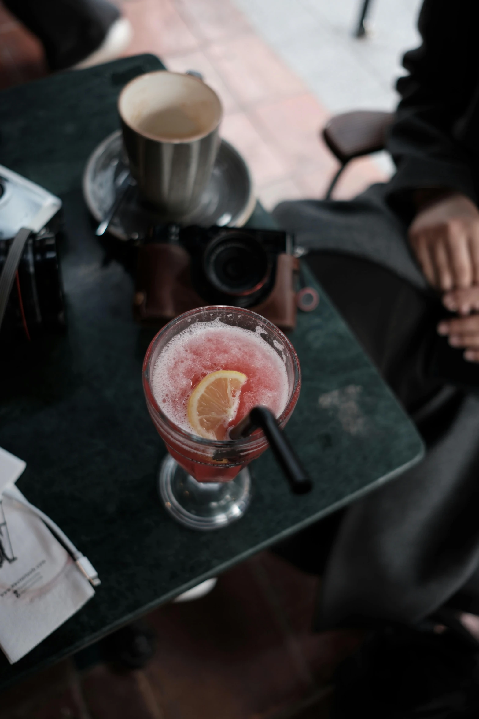 a glass with some red liquid on a table