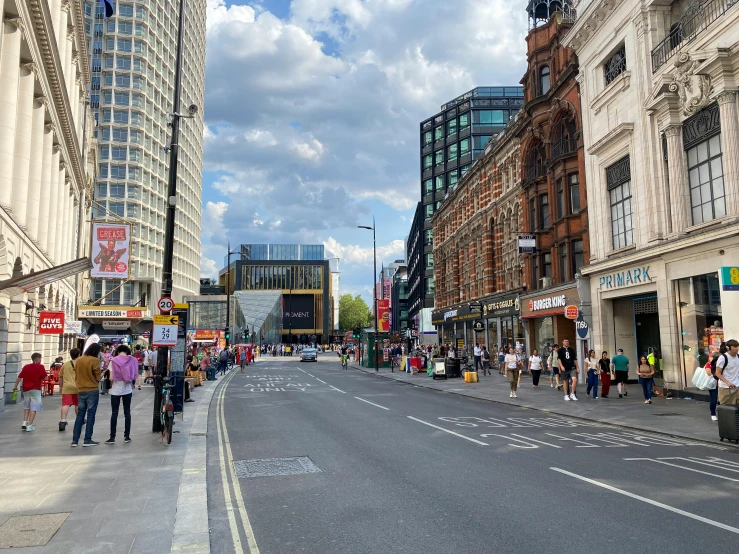 a busy street with stores in the center and people walking on it