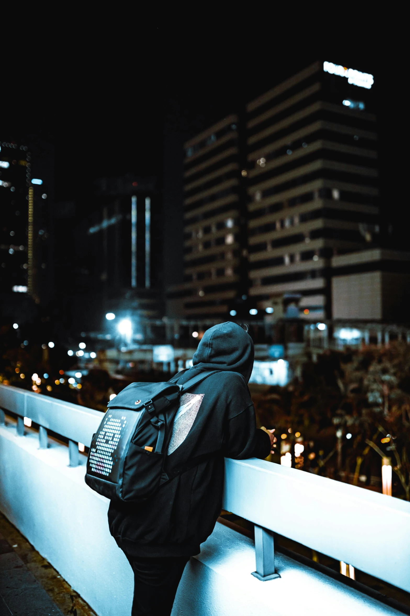 a person with a backpack on is looking over a city