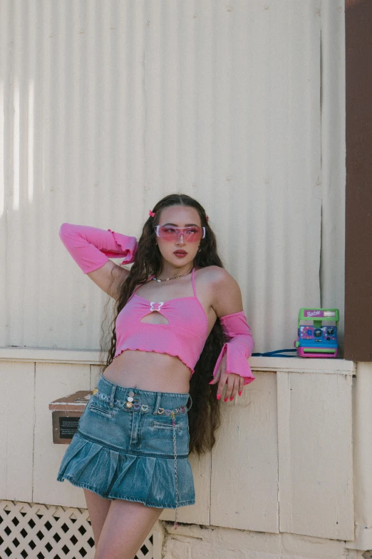 a girl is standing on a wall wearing glasses