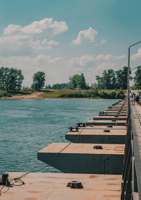 a row of concrete benches facing a lake