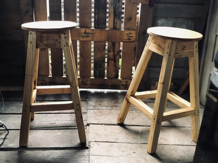 two wooden stools sitting on a porch