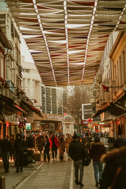 a group of people walking along a street lined with shops