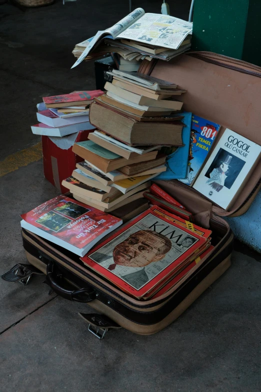 many books are piled together in a suitcase