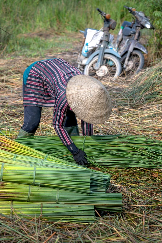 a person bending over in some grass while hing a moped