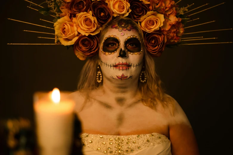 a girl dressed in white with floral crown and skull makeup