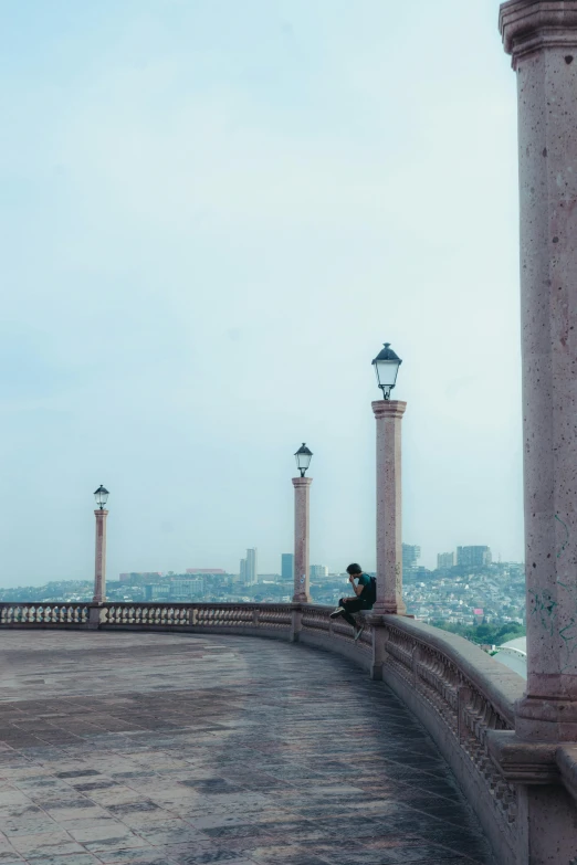 a person taking a picture while sitting on the stone wall