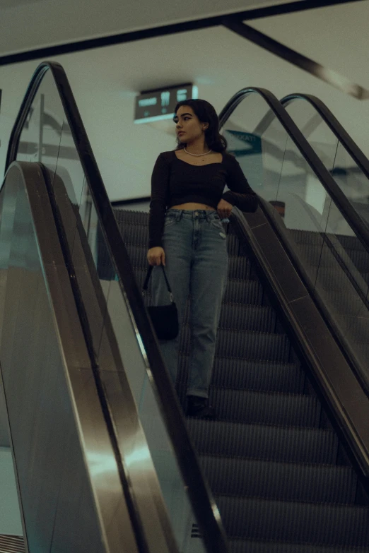 a woman riding on an escalator while holding her purse