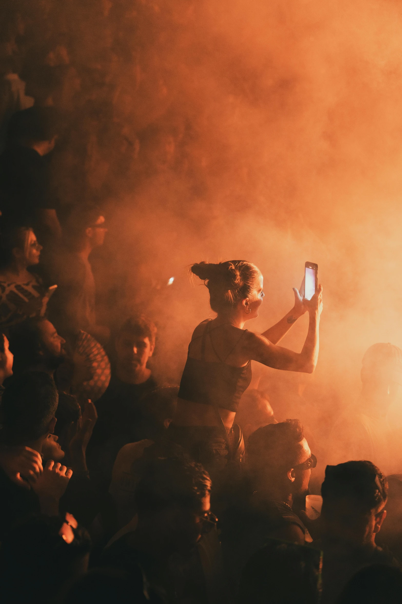 people standing in front of a small red fire