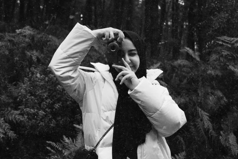 a woman is standing in the woods on her cellphone