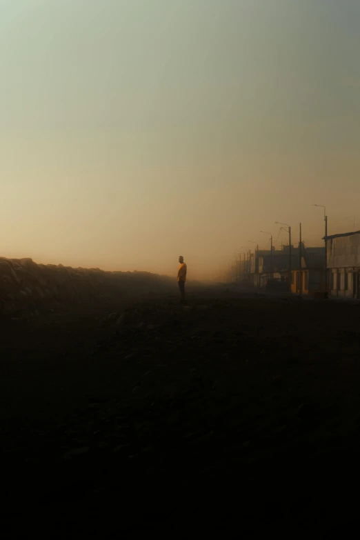 a man is standing alone outside in the sunset