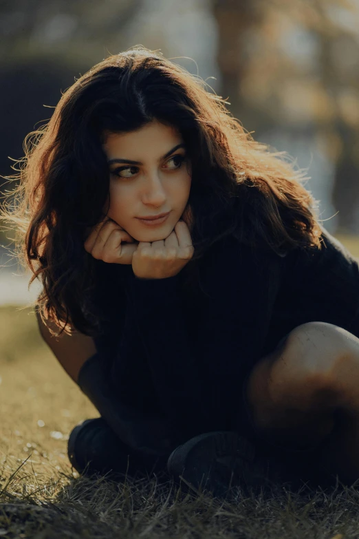 the young woman is posing on the grass