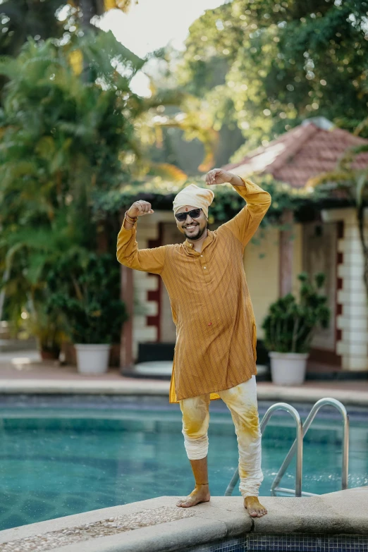 an indian man by the pool with sunglasses