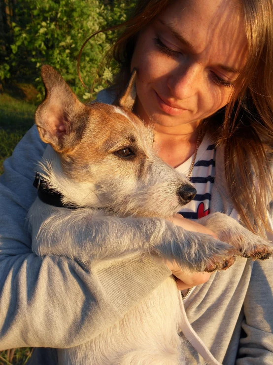 a woman that is holding a dog in her hand