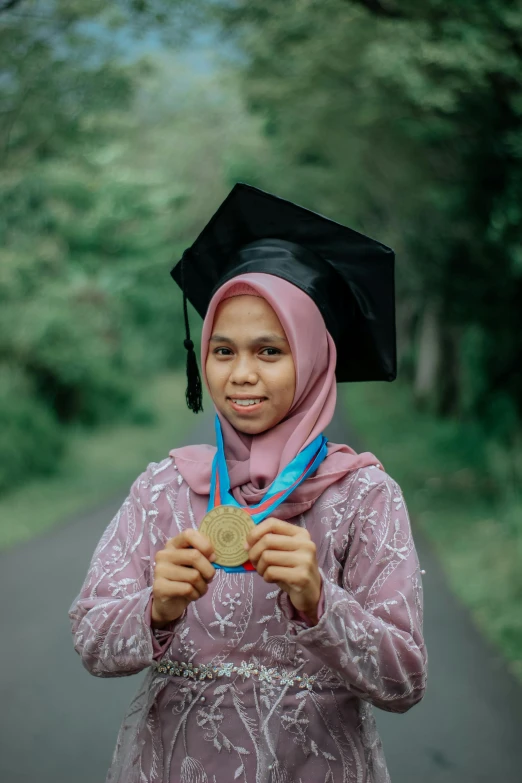 a woman wearing a graduation gown with a medal around her neck