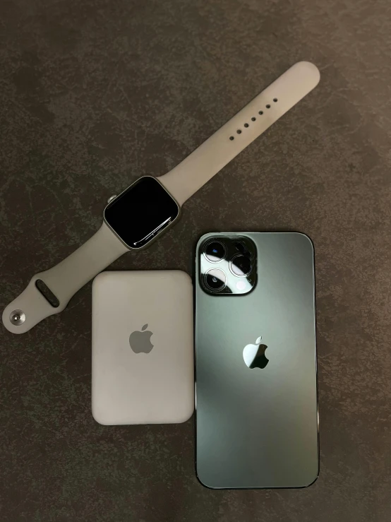 an apple watch and iphone are sitting next to each other