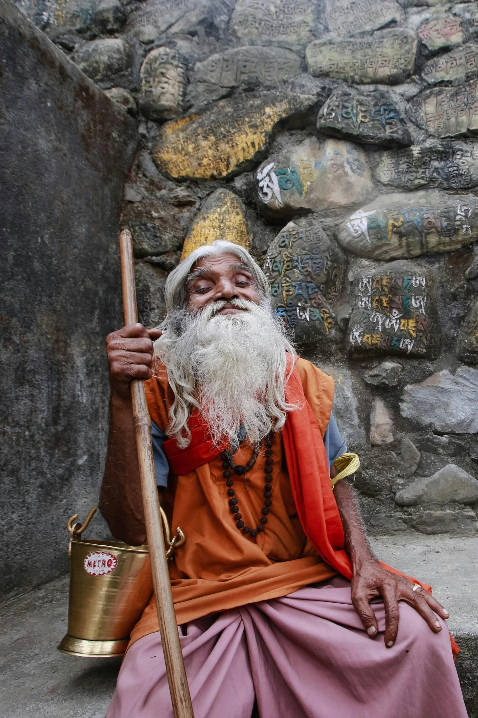 a bearded old man sitting with a long beard and a big stick