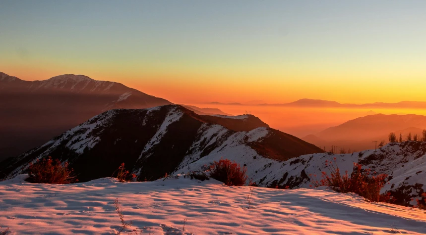 an image of the sun setting on a mountain