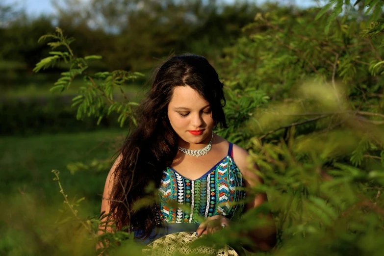 a woman with long hair standing among tall grass