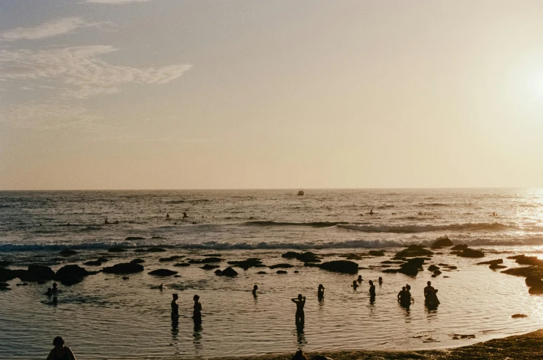 people in the water at the beach on a nice day