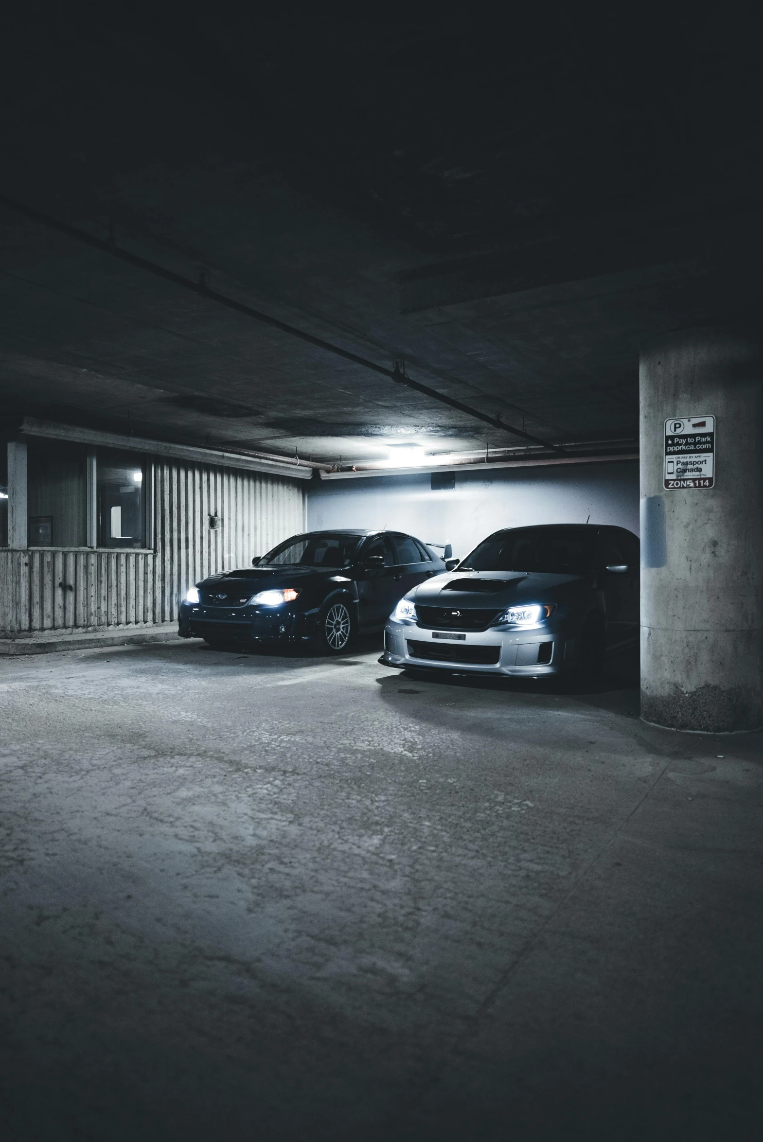 two cars parked in a very dark parking lot