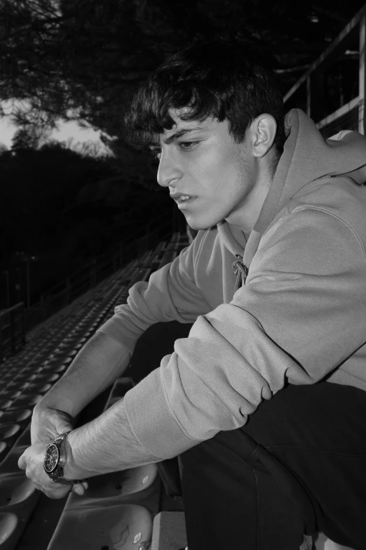 a man sitting on a bench wearing a watch