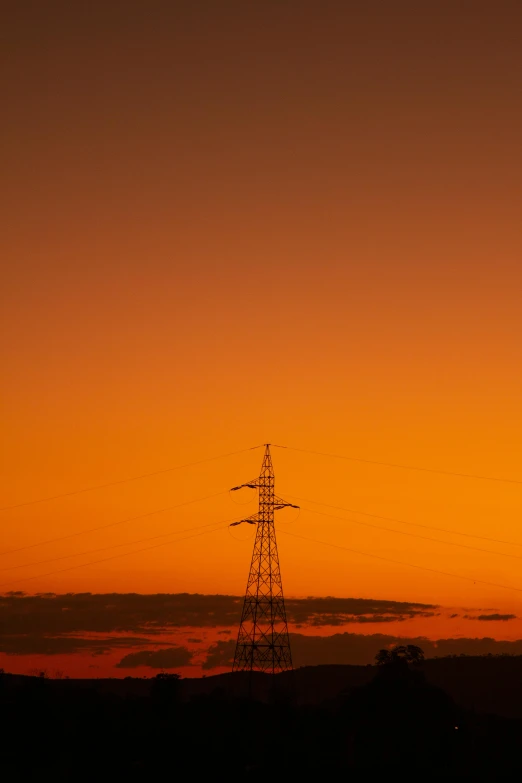 a tower in the distance under an orange sky