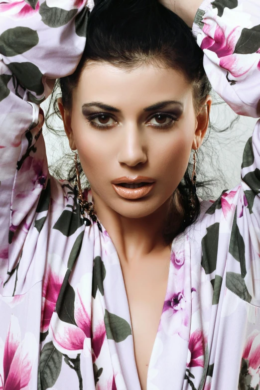 a woman posing for the camera with her hands on her head