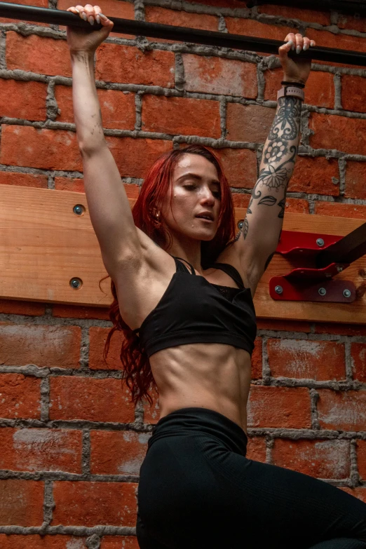 a woman holding onto a pole in a gym