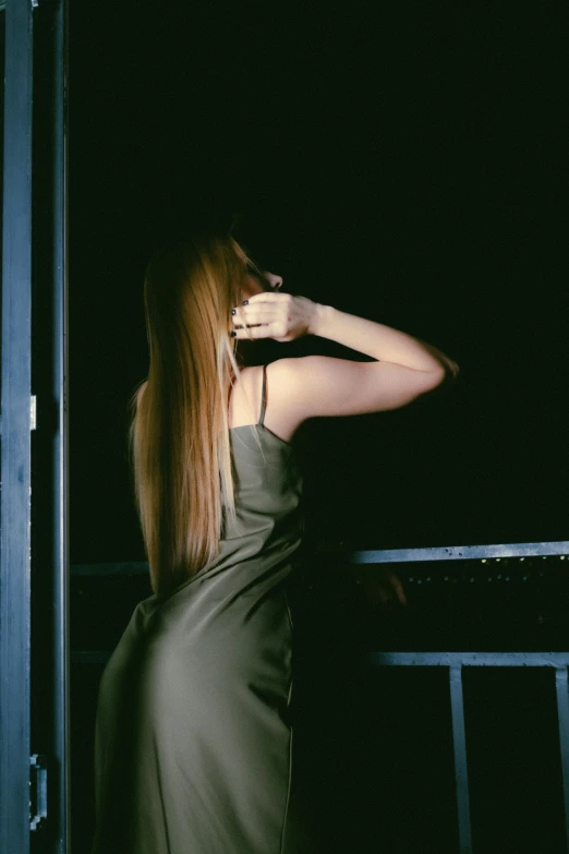 a woman with long hair is standing outdoors at night