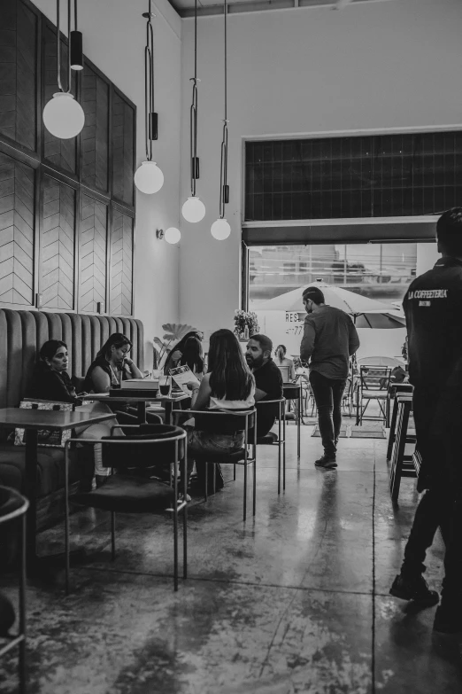 many people sitting at tables in a cafe