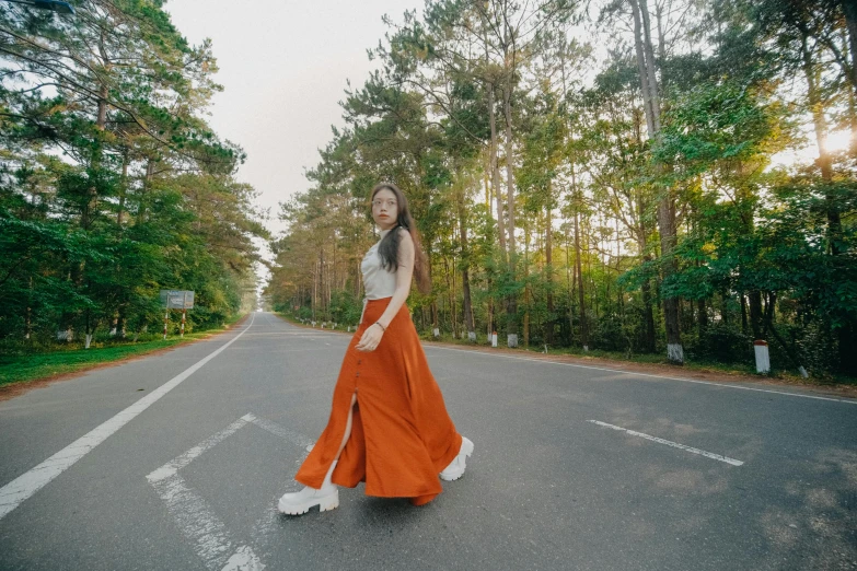 a young woman poses in the middle of an empty road