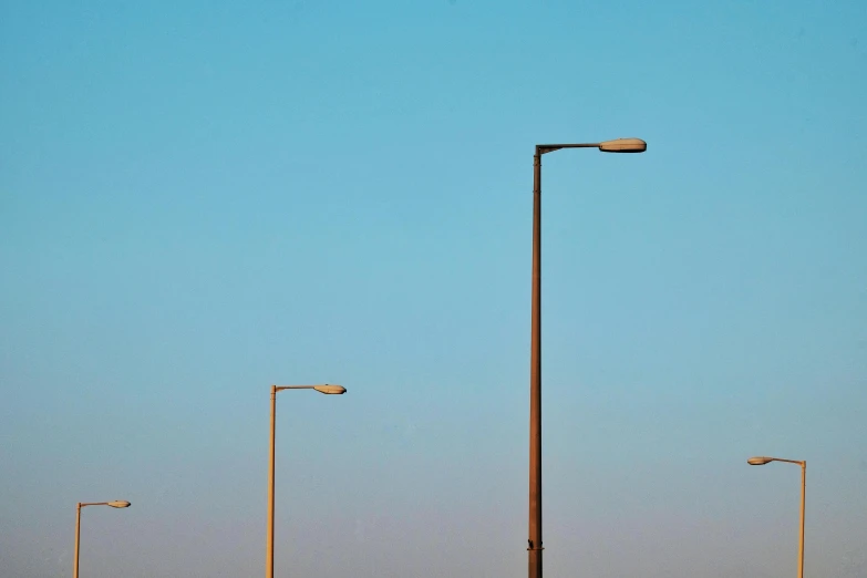 street lights against a pale blue sky in a deserted setting