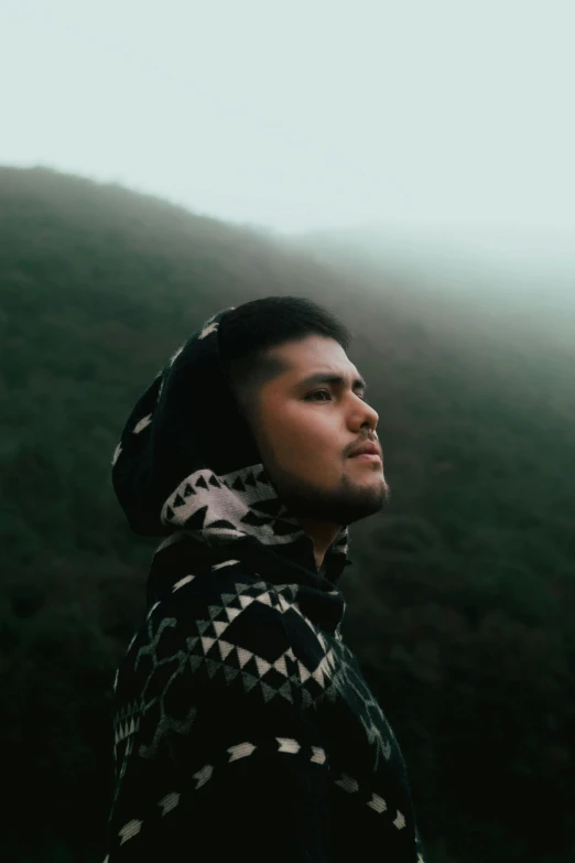 a man stands in the mist in a shawl