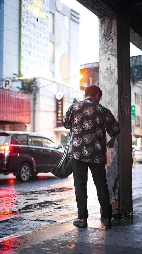 a man standing on a sidewalk in the rain