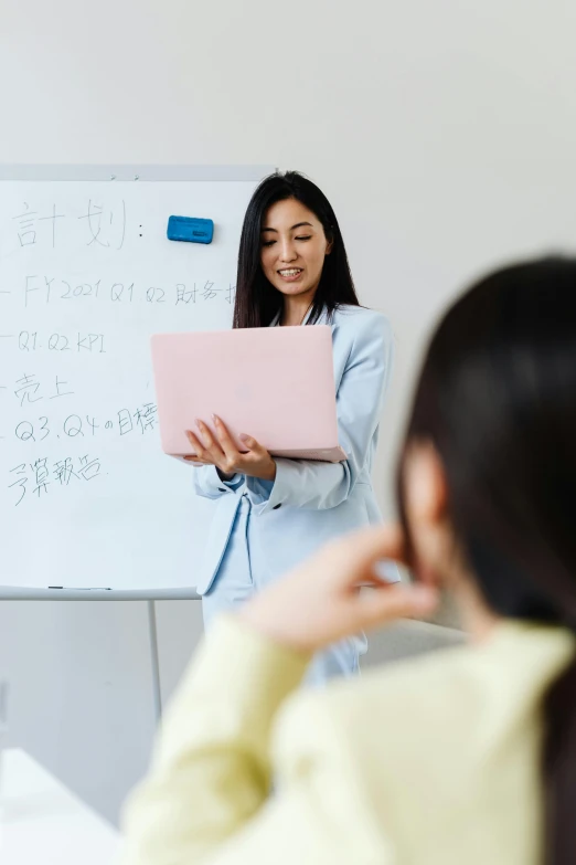 a woman holding a pink board next to a person